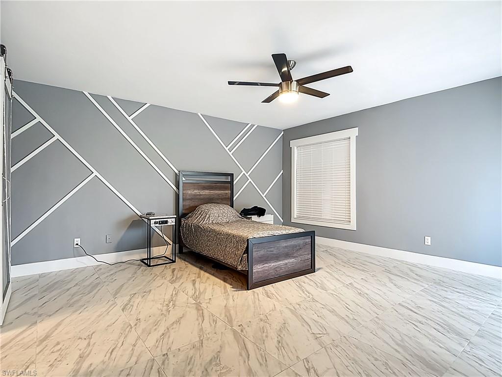 183 Round Key Circle, Unit D4 Naples, FL 34112 - Photo 33 of 49 a bedroom with a bed and a ceiling fan