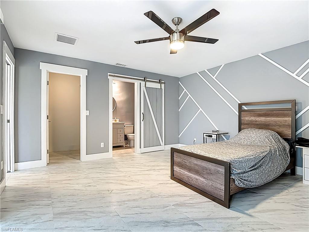 183 Round Key Circle, Unit D4 Naples, FL 34112 - Photo 34 of 49 a spacious bedroom with a bed and a chandelier
