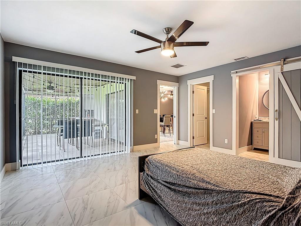 183 Round Key Circle, Unit D4 Naples, FL 34112 - Photo 35 of 49 a bedroom with a large bed and a chandelier