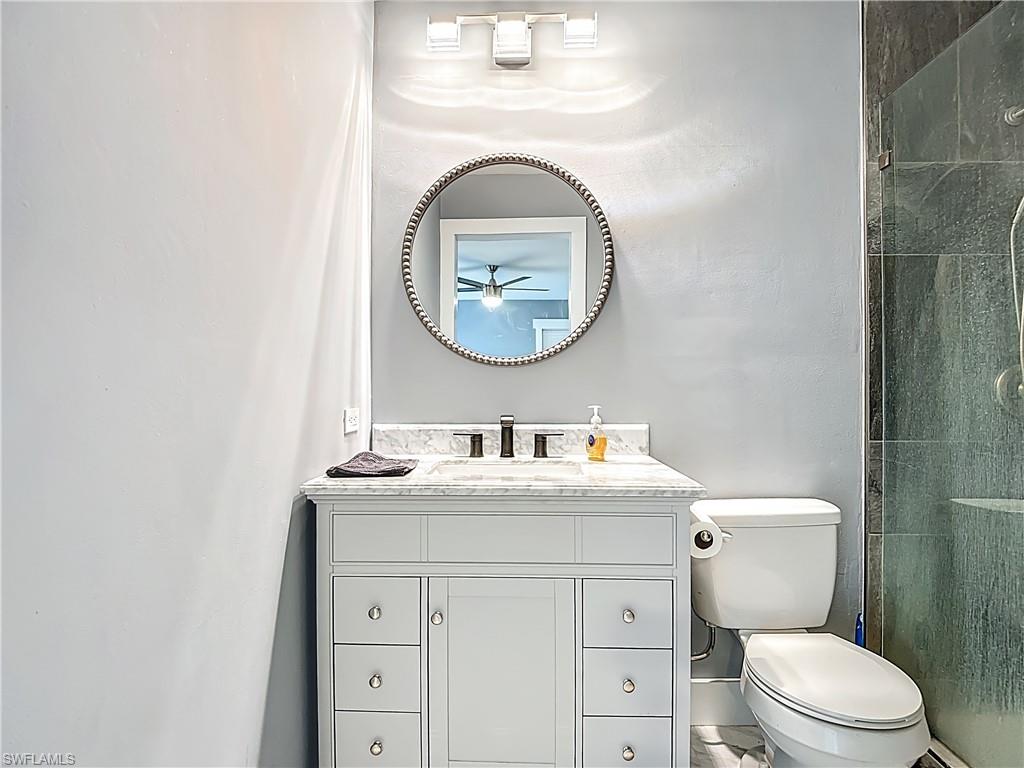 183 Round Key Circle, Unit D4 Naples, FL 34112 - Photo 36 of 49 a bathroom with a toilet sink vanity and mirror