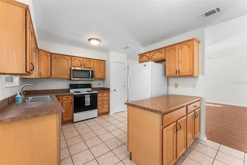 2026 Southwest 73rd Street Gainesville, FL 32607 - Photo 6 of 20 a kitchen with stainless steel appliances granite countertop a stove a sink and a refrigerator