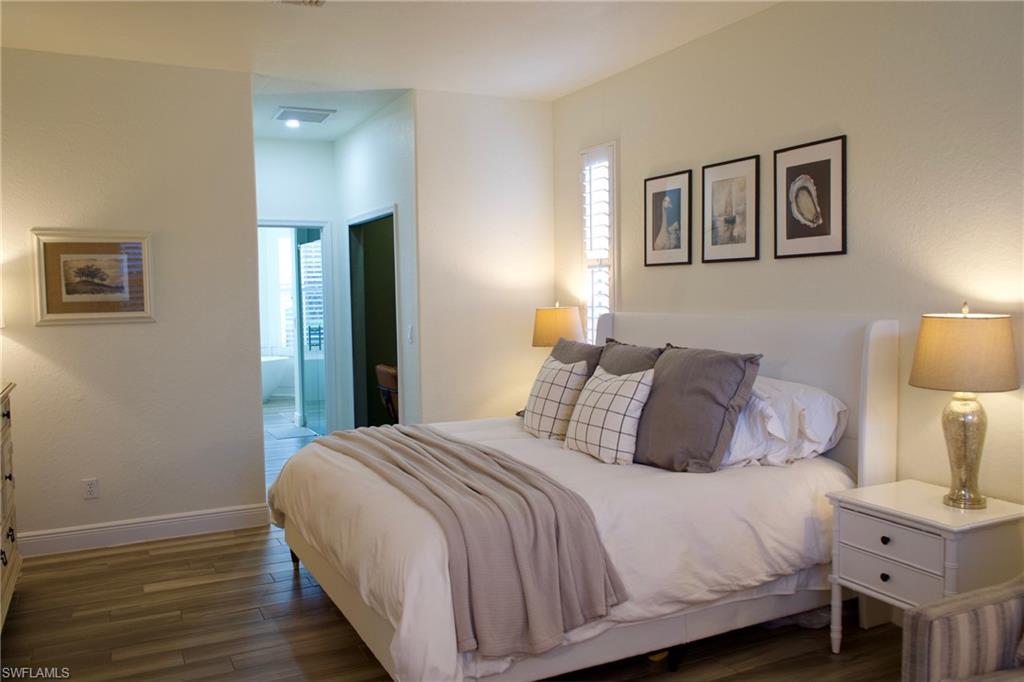 3944 Ruxton Road Naples, FL 34116 - Photo 14 of 27 a bedroom with a bed and a lamp