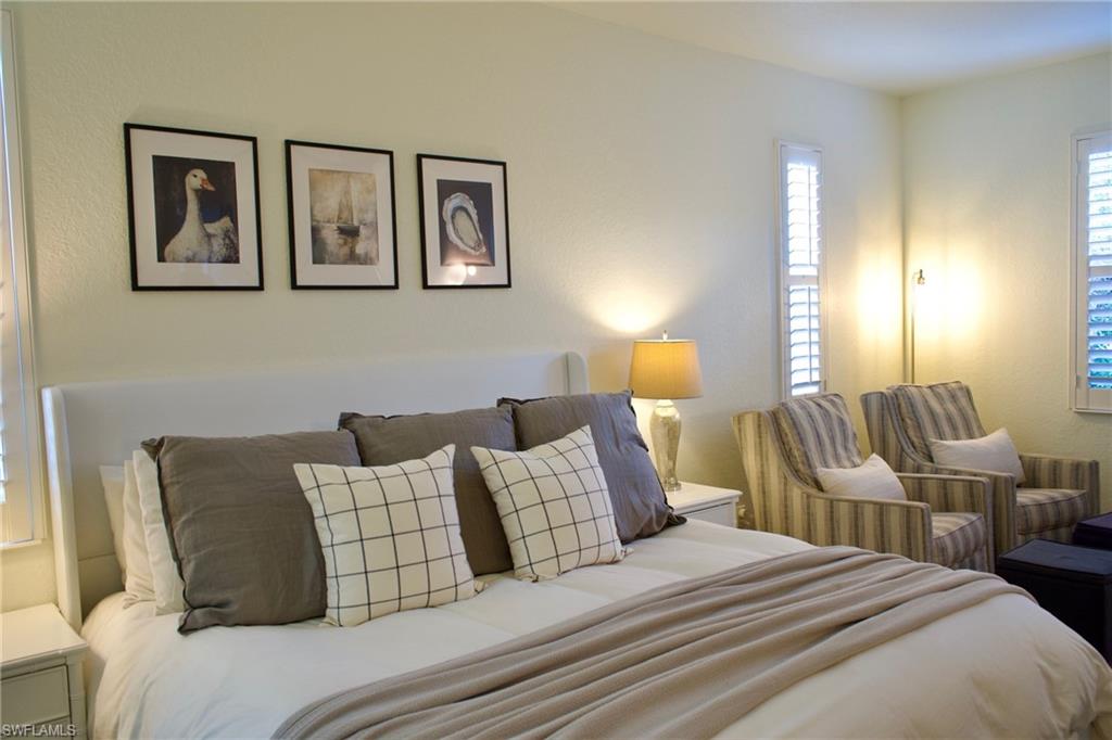 3944 Ruxton Road Naples, FL 34116 - Photo 15 of 27 a bedroom with a bed and lamp