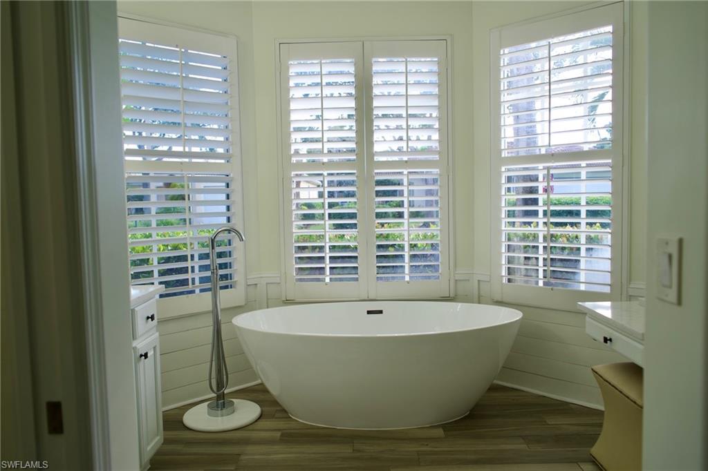 3944 Ruxton Road Naples, FL 34116 - Photo 18 of 27 a white bath tub sitting in a bathroom next to a window