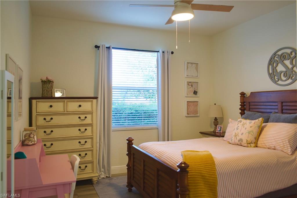 3944 Ruxton Road Naples, FL 34116 - Photo 25 of 27 a bedroom with a bed and a chandelier