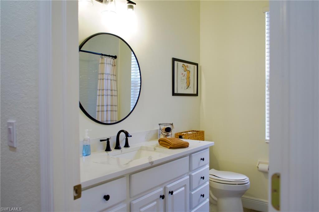 3944 Ruxton Road Naples, FL 34116 - Photo 27 of 27 a bathroom with a toilet a sink and a mirror