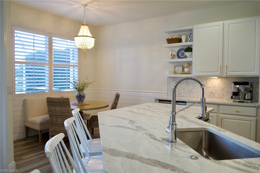 3944 Ruxton Road Naples, FL 34116 - Photo 8 of 27 a kitchen with a sink a counter space and a dining table