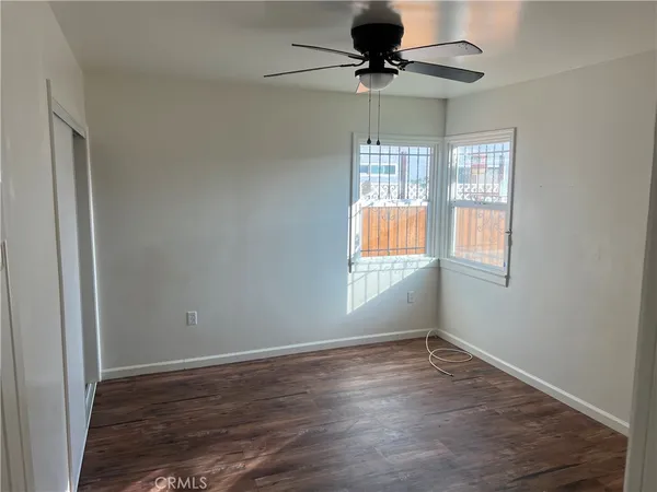 a view of room with hardwood floor and ceiling fan
