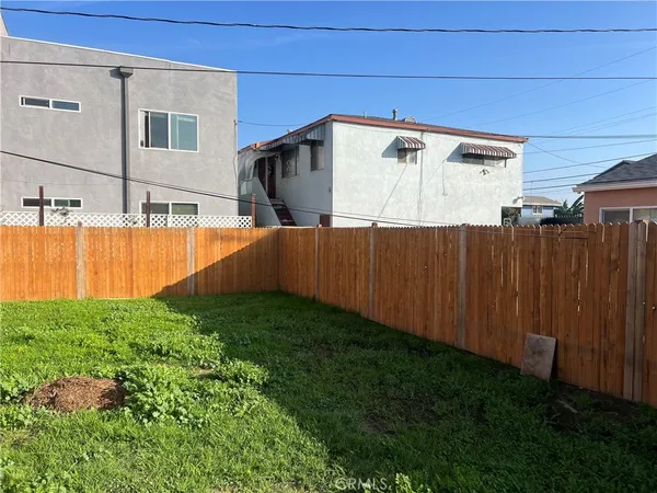a view of a backyard with wooden fence