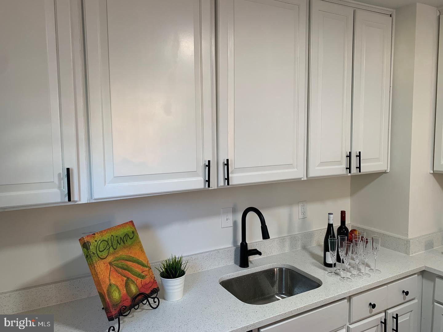 9407 Colesville Road Silver Spring, MD 20901 - Photo 14 of 47 Modern kitchen with sleek white cabinetry.
