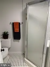 a bathroom with a toilet a light fixture and a shower