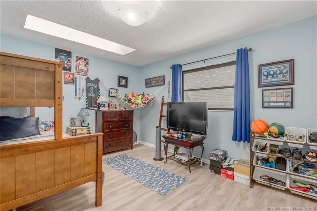 1743 Northwest Spruce Ridge Drive Stuart, FL 34994 - Photo 15 of 31 a bedroom with furniture and a wooden floor