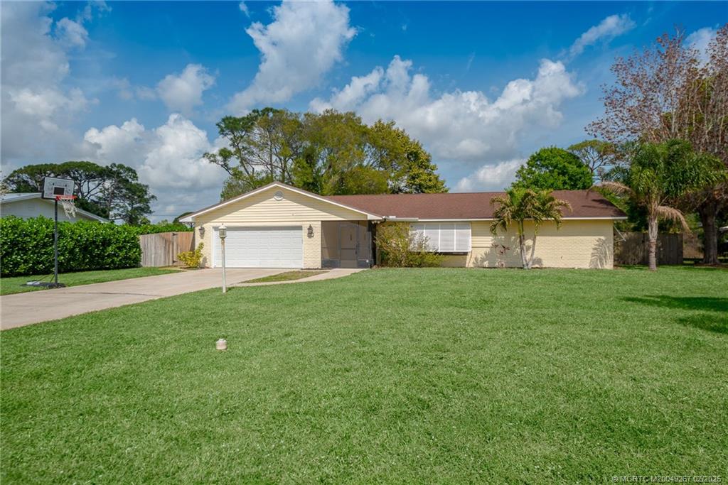 1743 Northwest Spruce Ridge Drive Stuart, FL 34994 - Photo 2 of 31 a front view of a house with garden