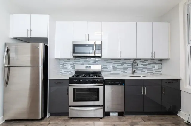 a kitchen with appliances a sink and cabinets