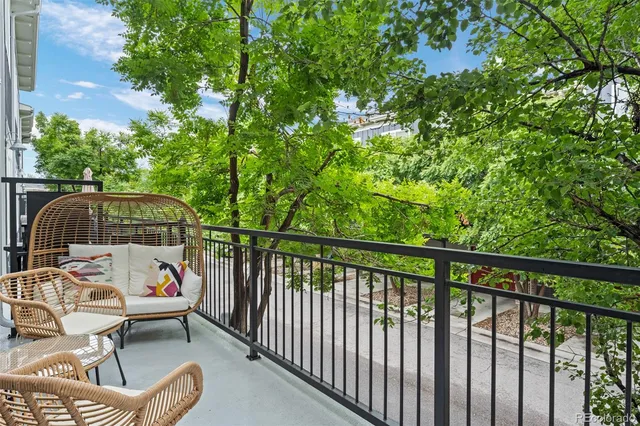 a roof deck with table and chairs under an umbrella