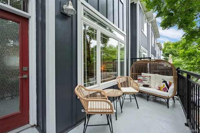 a patio with a table and chairs and potted plants