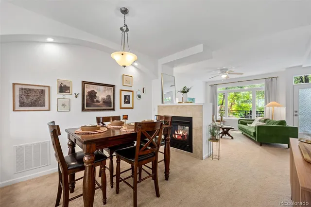 a dining room with furniture a fireplace and a chandelier