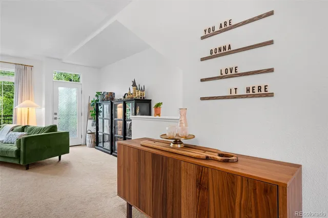 a living room with furniture mirror and a window