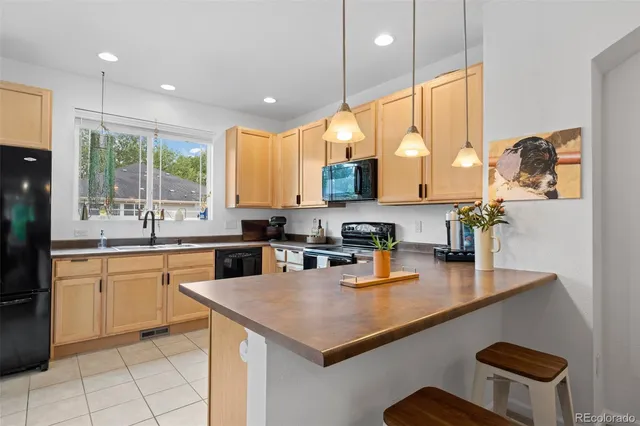 a kitchen with a sink a counter top space appliances and cabinets