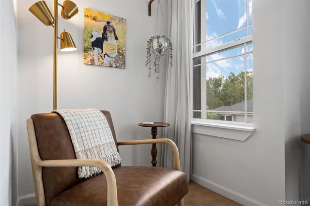 a view of a workspace with furniture and a window