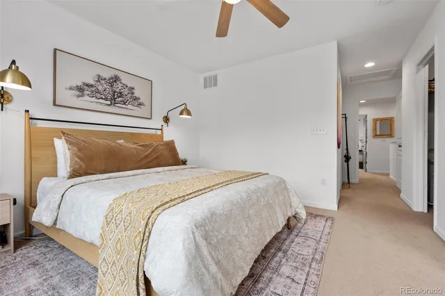 a bedroom with bed and paintings on the wall