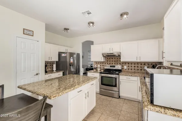a kitchen with stainless steel appliances granite countertop a stove oven and a refrigerator