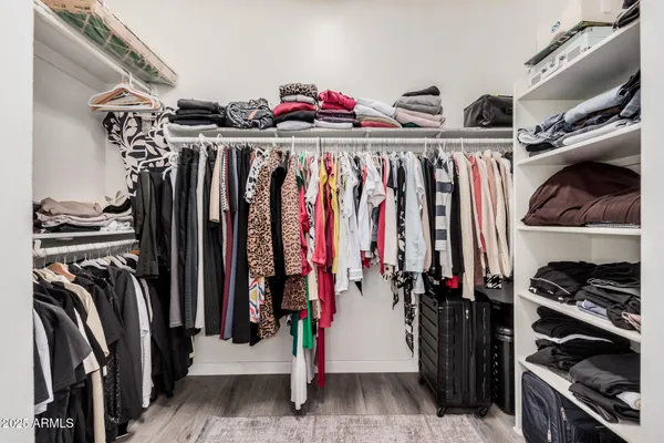 a view of walk in closet with clothes and shoes