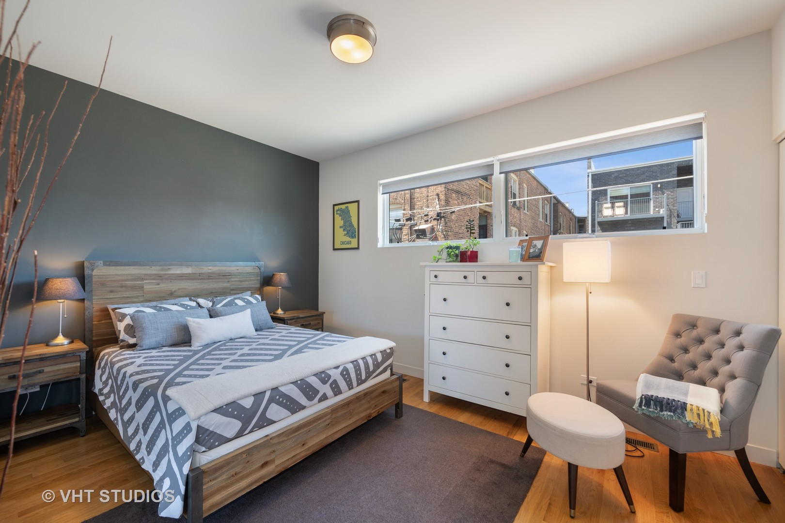 4832 North Clark Street, Unit 117 Chicago, IL 60640 - Photo 10 of 13 a bedroom with a bed and chair