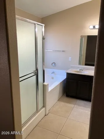 a bathroom with a double vanity sink a mirror and a bathtub