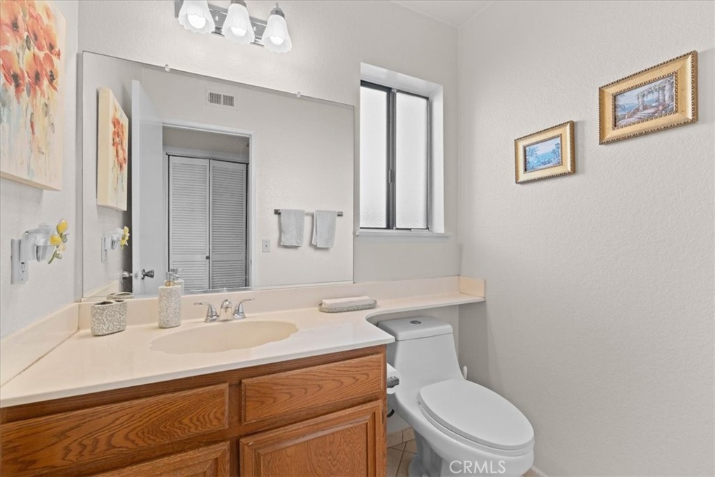 10536 Deerfield Drive Rancho Cucamonga, CA 91701 - Photo 13 of 28 a bathroom with a toilet a sink and mirror