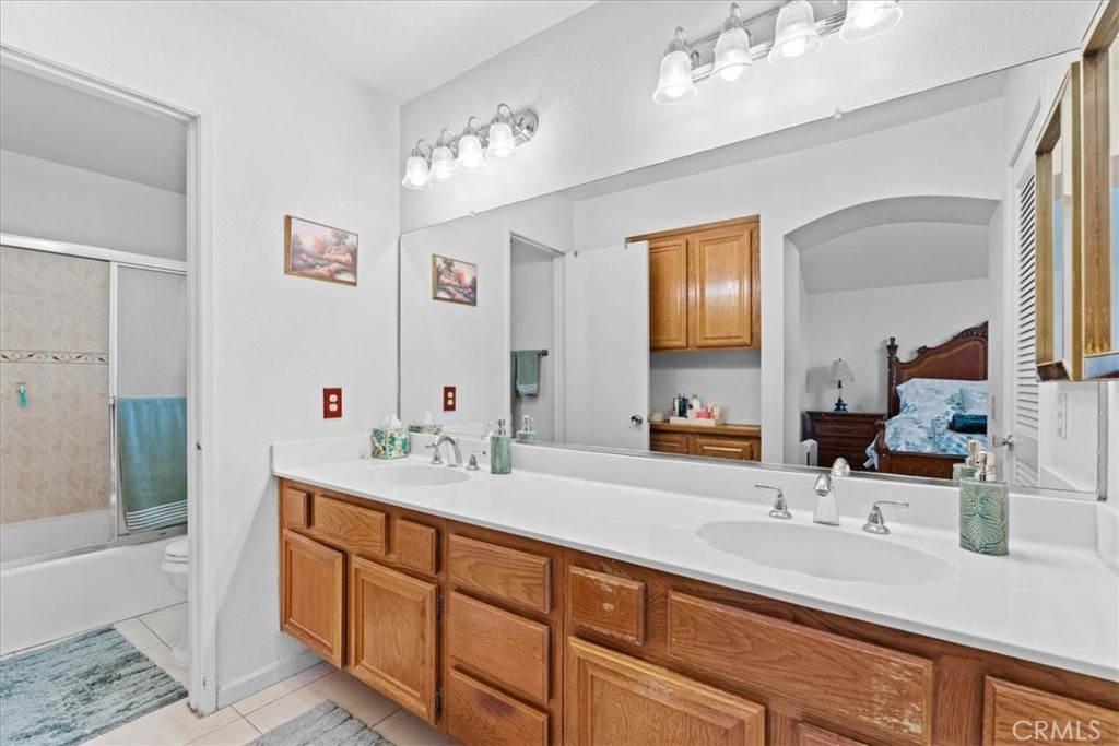 10536 Deerfield Drive Rancho Cucamonga, CA 91701 - Photo 19 of 28 a bathroom with a sink double vanity granite tub and a mirror