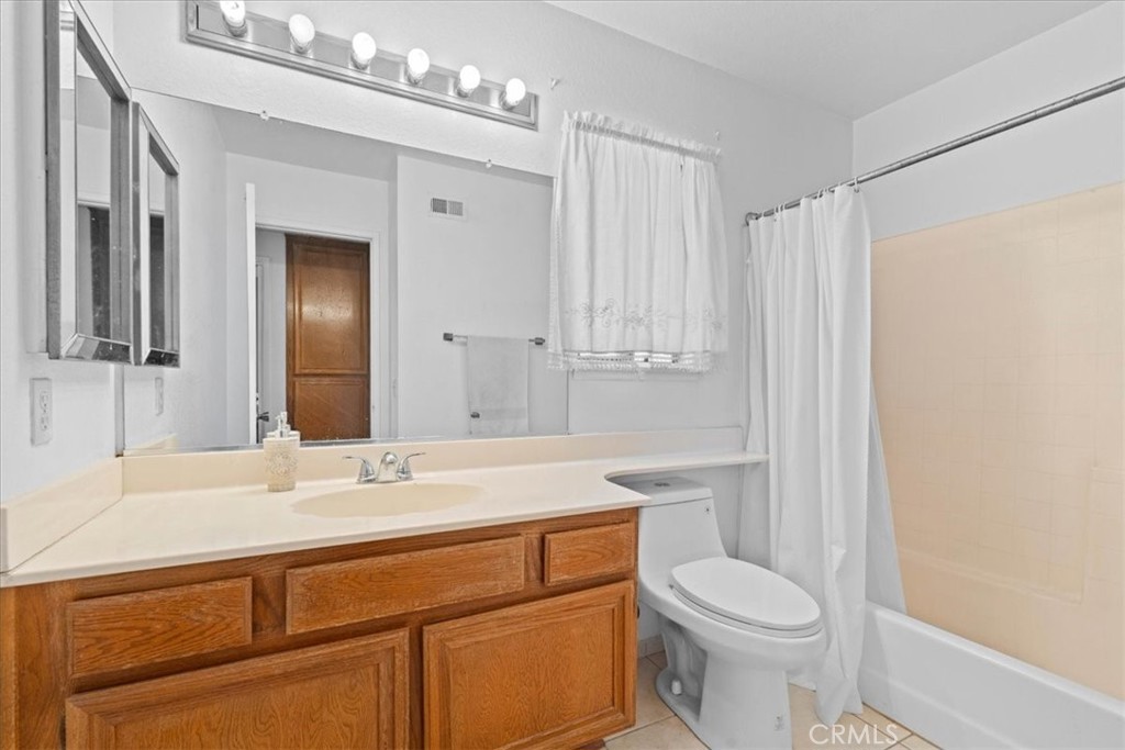 10536 Deerfield Drive Rancho Cucamonga, CA 91701 - Photo 22 of 28 a bathroom with a sink a toilet a mirror and vanity