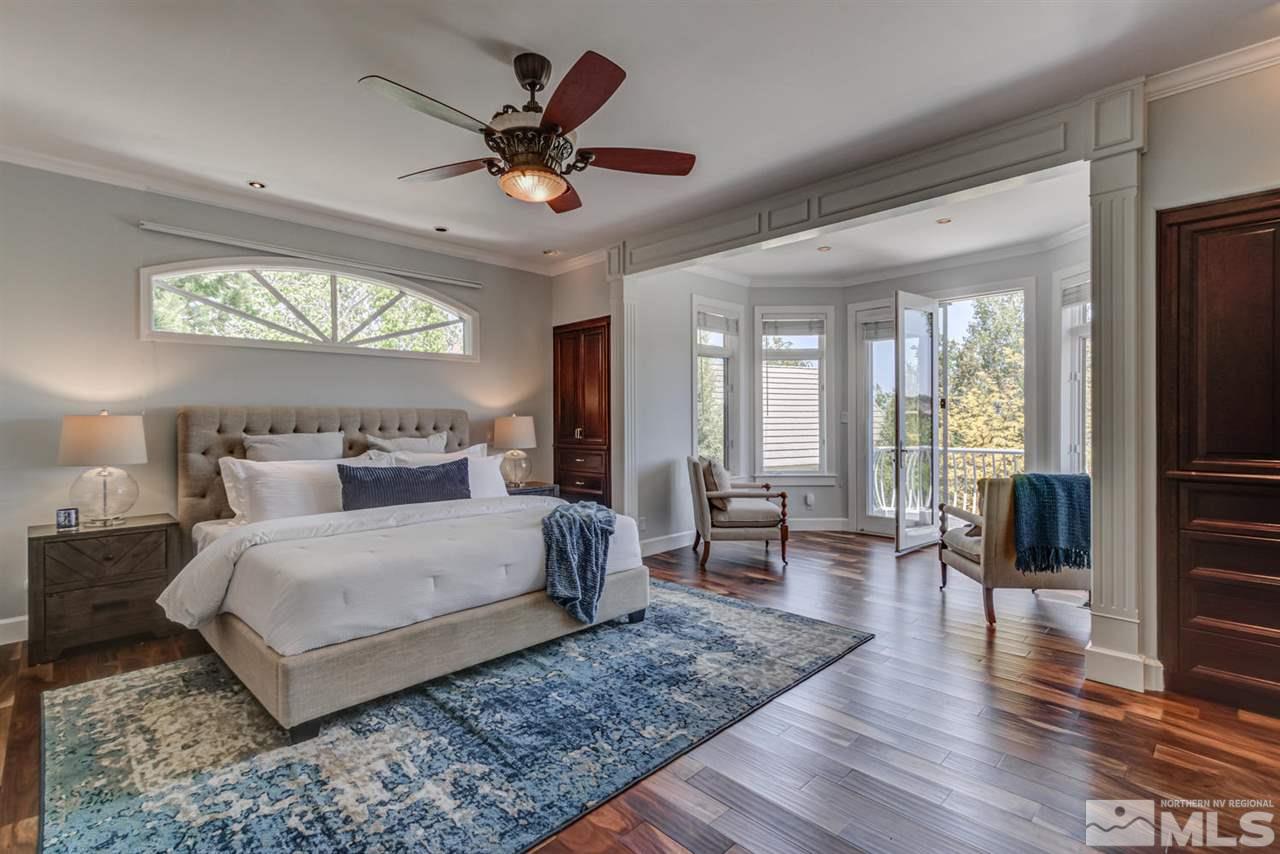 25 Promontory Pointe Reno, NV 89519 - Photo 17 of 40 a bedroom with a large bed a chandelier and windows