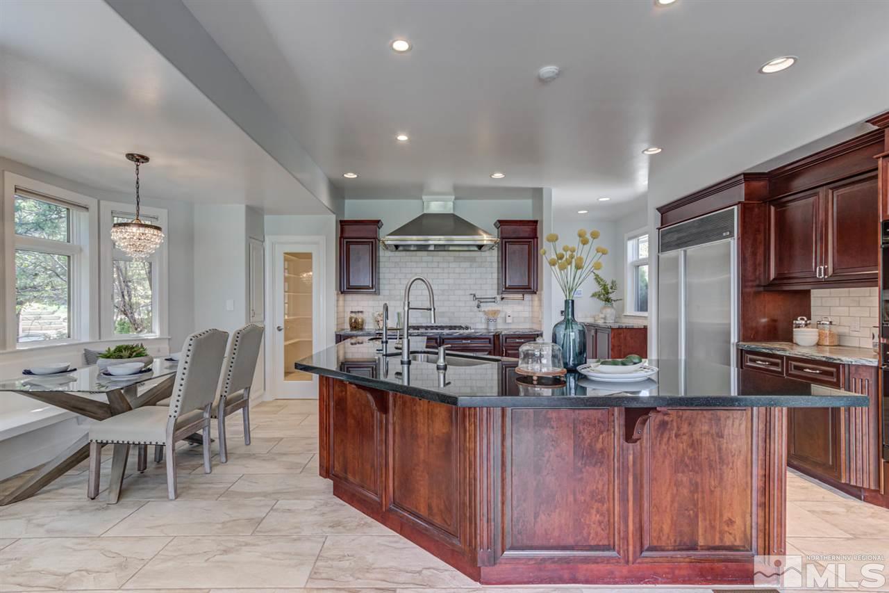 25 Promontory Pointe Reno, NV 89519 - Photo 9 of 40 a kitchen with stainless steel appliances granite countertop table chairs stove and cabinets