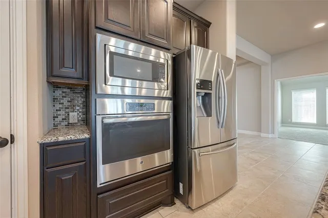 a large kitchen with granite countertop a sink and a stove top oven