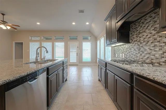 a view of kitchen with refrigerator sink and wooden cabinets