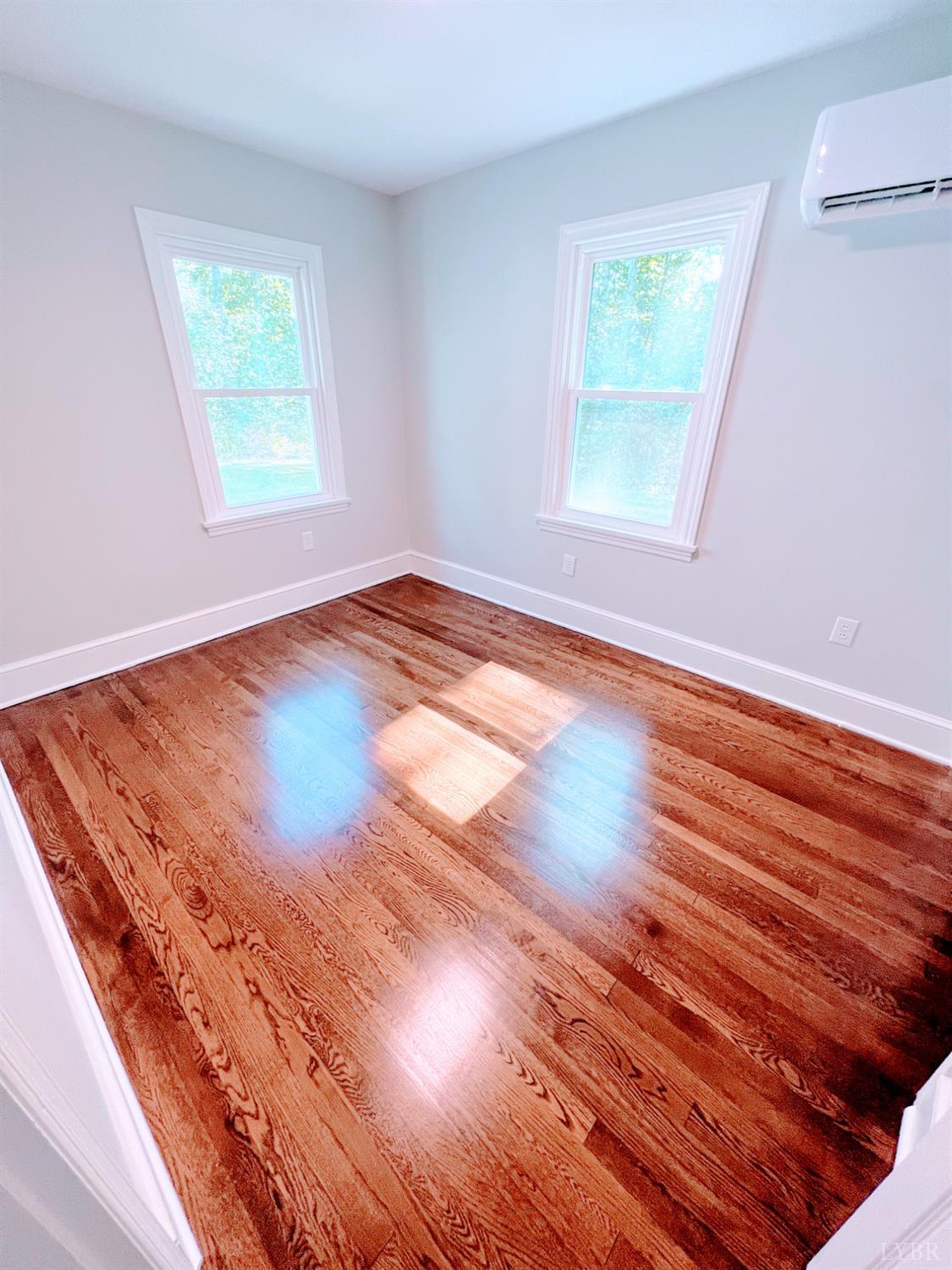 198 Woodbridge Lane Spout Spring, VA 24593 - Photo 20 of 27 an empty room with wooden floor and windows