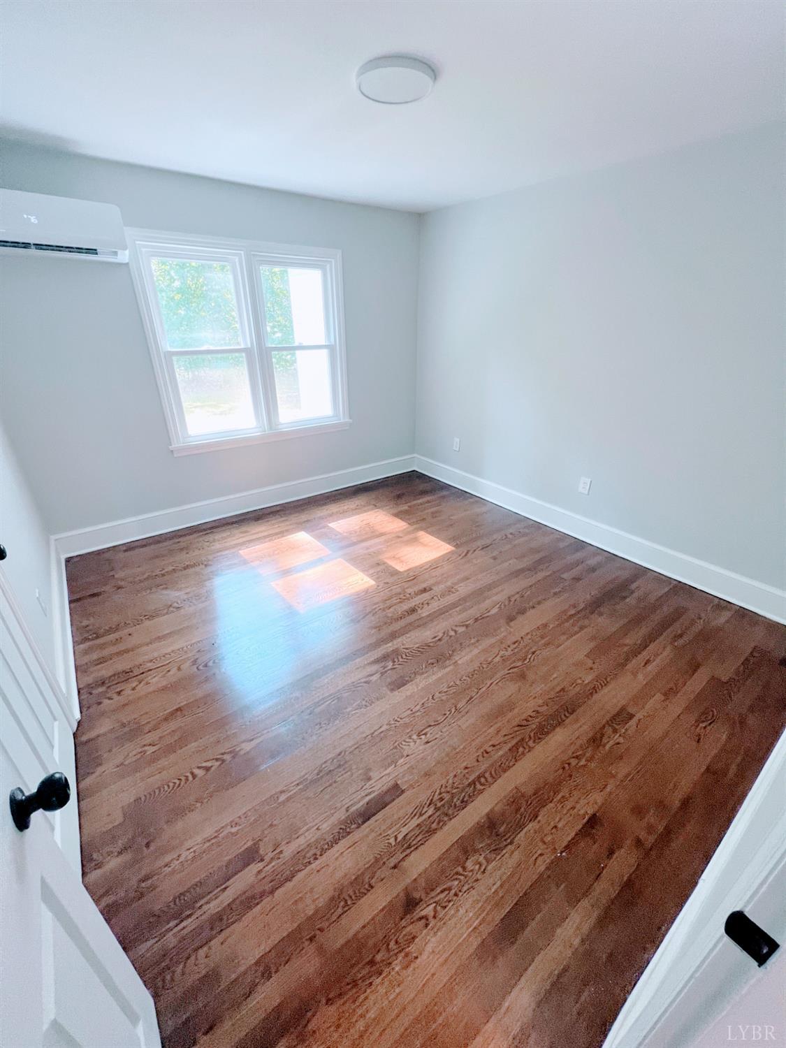 198 Woodbridge Lane Spout Spring, VA 24593 - Photo 22 of 27 an empty room with wooden floor and windows