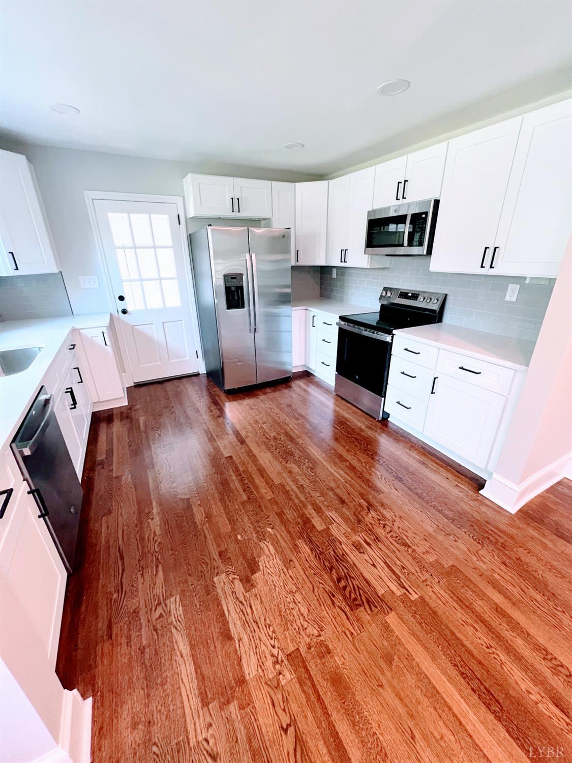198 Woodbridge Lane Spout Spring, VA 24593 - Photo 4 of 27 a kitchen with cabinets and wooden floor