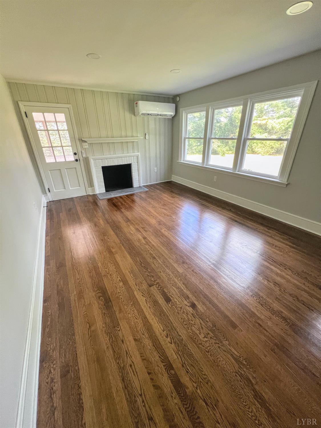 198 Woodbridge Lane Spout Spring, VA 24593 - Photo 8 of 27 an empty room with wooden floor and windows