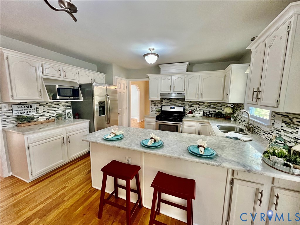 5617 Chatmoss Road Midlothian, VA 23112 - Photo 8 of 23 a kitchen with stainless steel appliances granite countertop a stove a sink a stove a dining table and chairs