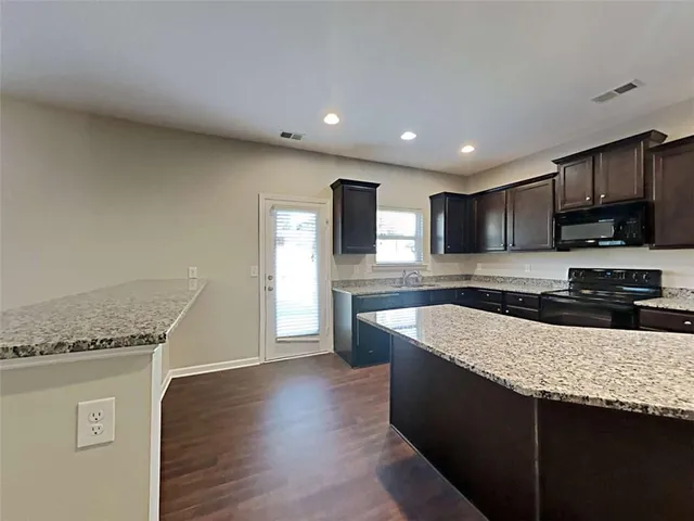 a kitchen with granite countertop stainless steel appliances and wooden cabinets
