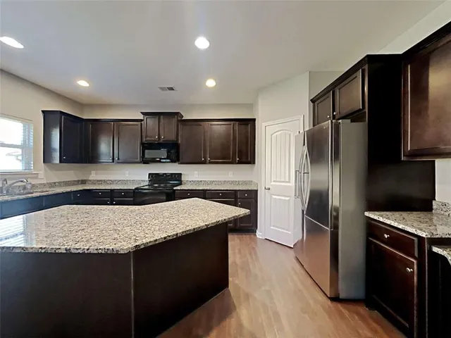 a kitchen with a refrigerator sink and wooden cabinets