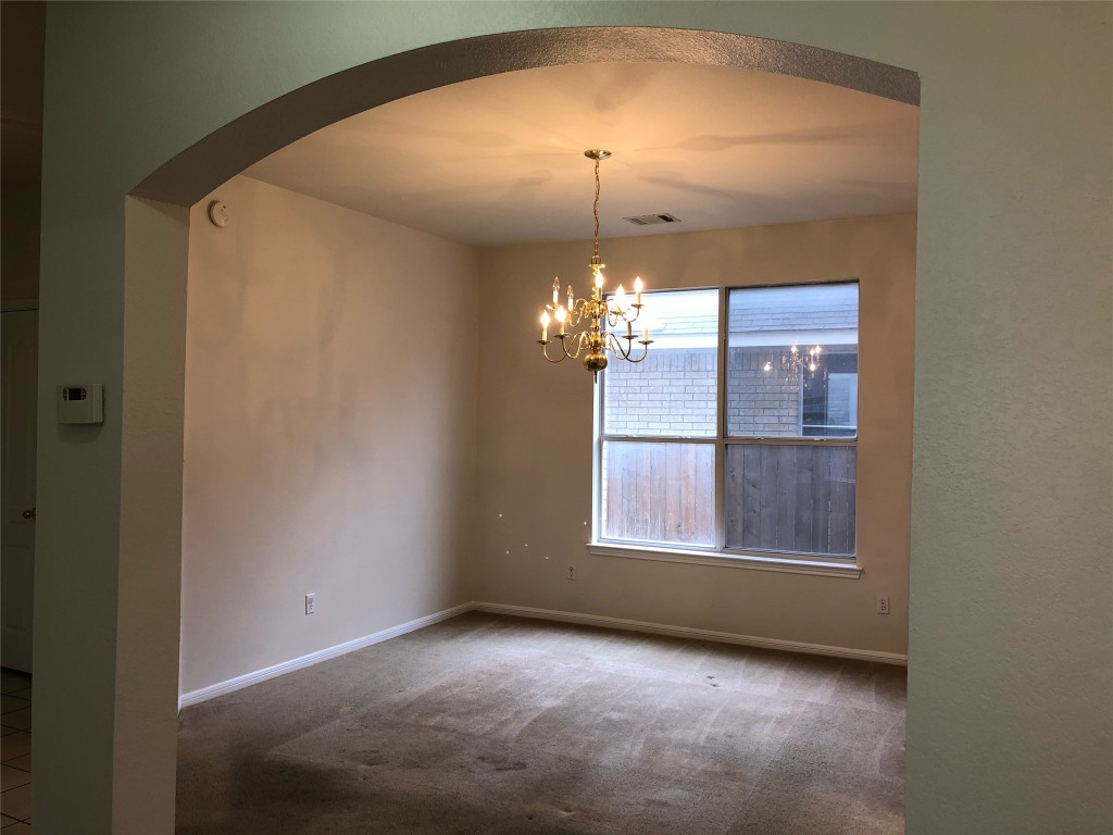 3604 Roller Crossing Austin, TX 78728 - Photo 14 of 40 Unfurnished dining area with carpet flooring, a chandelier, and arched walkways