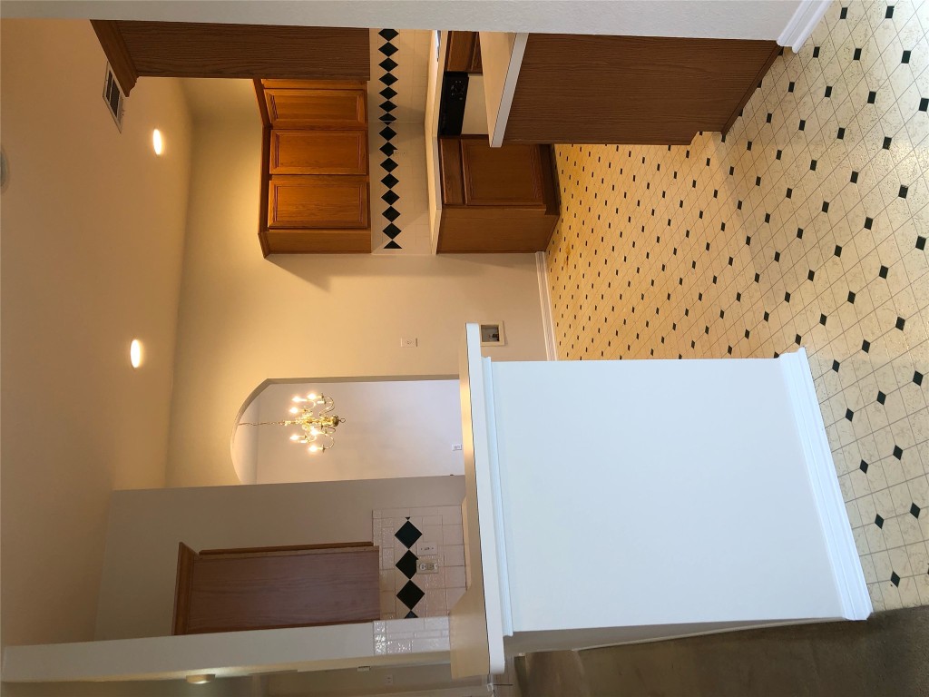 3604 Roller Crossing Austin, TX 78728 - Photo 21 of 40 Kitchen featuring light countertops, brown cabinetry, recessed lighting, a chandelier, and hanging light fixtures