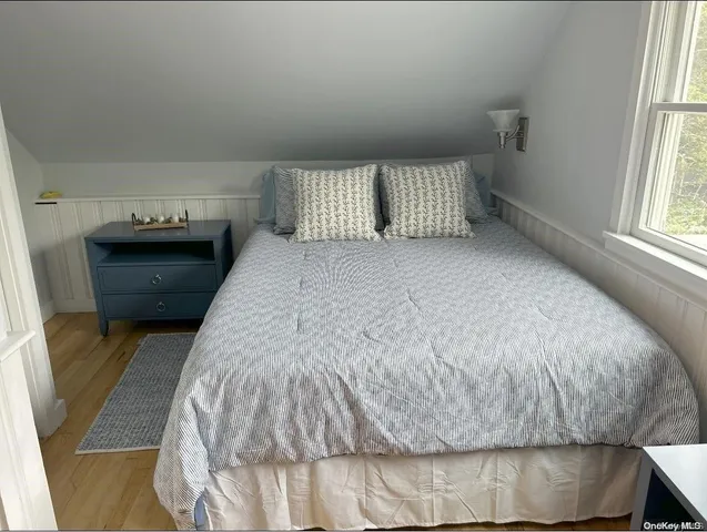 a bed sitting in a bedroom next to a window