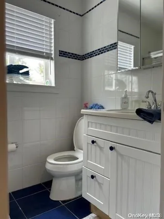 a bathroom with a sink a toilet and a window