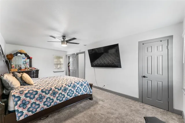 a bedroom with a large bed and a flat screen tv