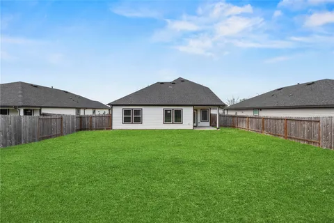 a view of a big house with a big yard and large trees