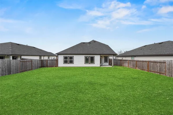 a view of a big house with a big yard and large trees